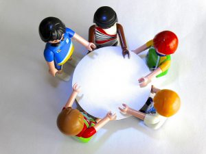 besluitvorming aan ronde tafel met playmobilpoppetjes